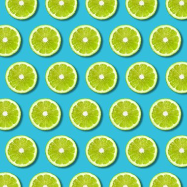 Yeşil limon dilimleri desen canlı turkuaz renkli arka plan üzerinde. En az düz gıda doku yatıyordu 