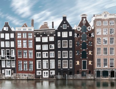 Uzun pozlama resmi geleneksel Amsterdam eski kent mimarisiyle tipik Hollanda evleri, hareket bulanıklığı kanal su ve bulutlar üzerinde