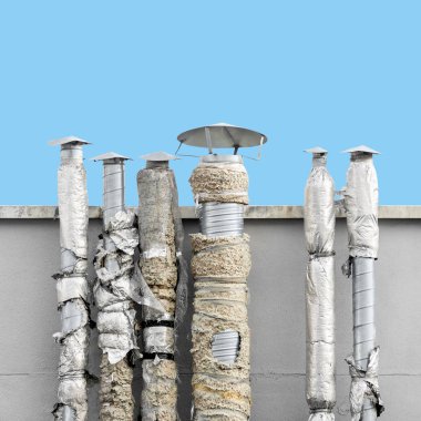 Close up of set of ventilation chimneys with damaged isolation against blue sky clipart