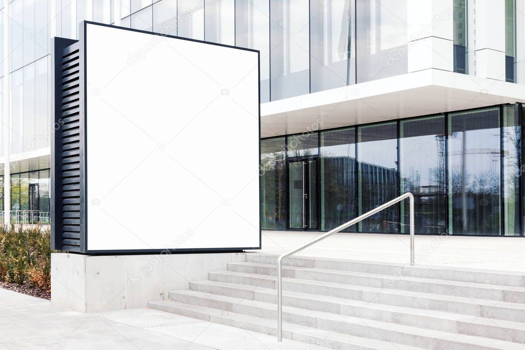 Large blank outdoor billboard template with white copy space to add multiple company names and logos with modern office building in background