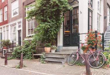 Tipik Amsterdam eski şehir cadde görünümü ile geleneksel yapılar ve sakin yaz gününde, hiçbir insan vintage Bisiklet