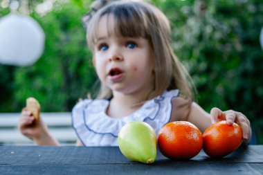 Çocuklar açık havada farklı meyveler ile oyun