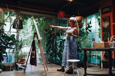 Profesyonel kadın sanatçı Studio bitkiler ile tuval üzerine boya kapalı atış.