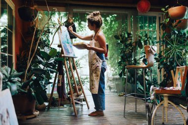 Profesyonel kadın sanatçı Studio bitkiler ile tuval üzerine boya kapalı atış.