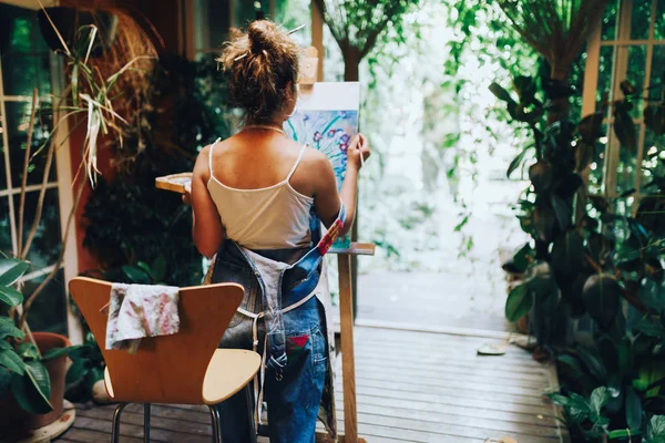 プロ女性アーティストの植物とスタジオでキャンバスに絵画の室内撮影 — ストック写真