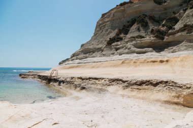 Paslı merdivenle arka planda Malta okyanusta yalnız Beach