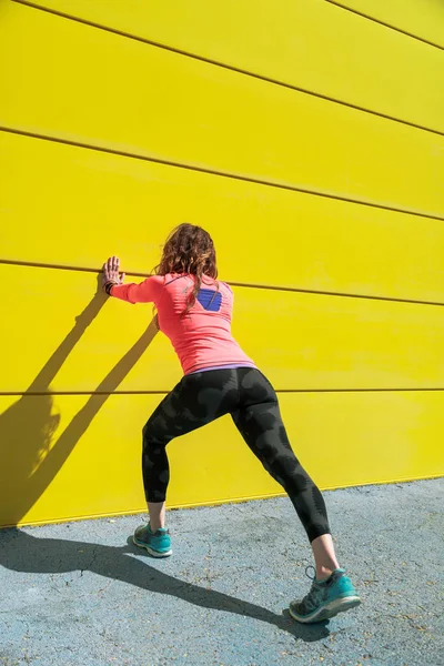 Jeune Femme Étirant Sur Mur Jaune Avant Courir — Photo