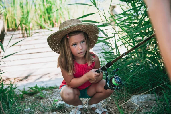 Little Blond Girl Straw Hat Prepares Her Fishing Rod Sitting Stock
