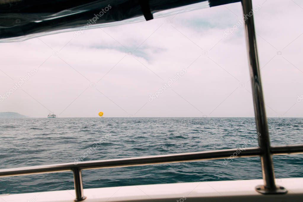 Views of an yellow entertainment parachute in the sea from inside a boat