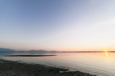 Ay ve güneş üzerinde sky ile Bavyera göl günbatımı astronomik birlikte