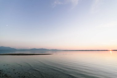 Ay ve güneş üzerinde sky ile Bavyera göl günbatımı astronomik birlikte