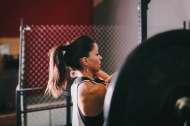 Atletik esmer genç kadının bazı halter egzersiz yapması