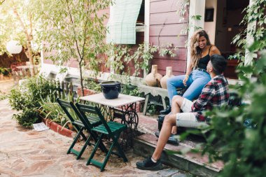 Bahçe Sandalye ahşap evlerinin onların akıllı telefon ile oturan genç çift gülümseyen