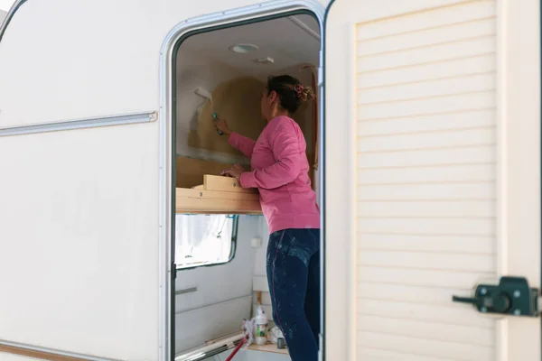 Młoda Blondynka kobieta malarstwo i przywracanie caravan — Zdjęcie stockowe