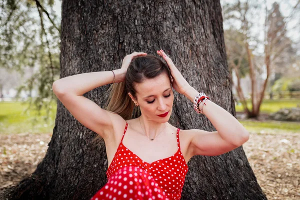 Junge blonde Frau macht einen Zopf mit rotem langen Kleid — Stockfoto