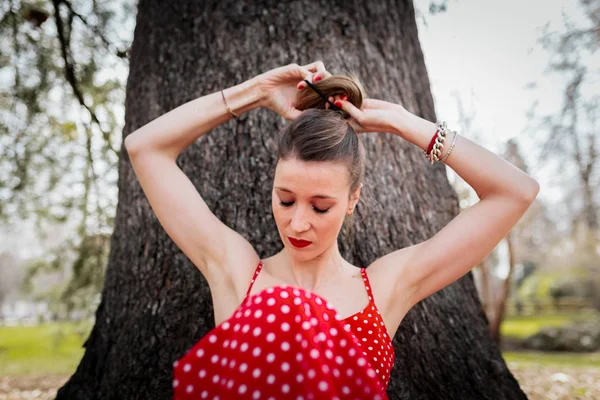 Jeune femme blonde faisant une queue de cochon avec robe longue rouge — Photo