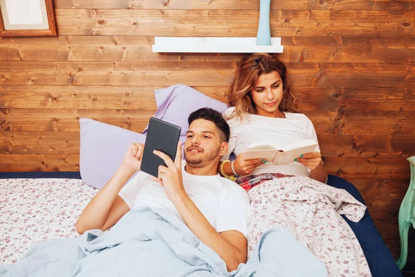 Jeune couple hétérosexuel souriant couché ensemble sur le lit — Photo