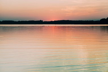Chiemsee gölünde ufkun arkasına saklanan güneş
