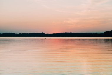 Chiemsee gölünde ufkun arkasına saklanan güneş