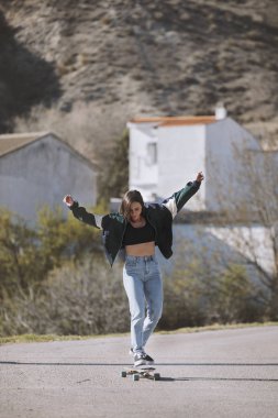 Bir kasaba yolunda pateni olan kız