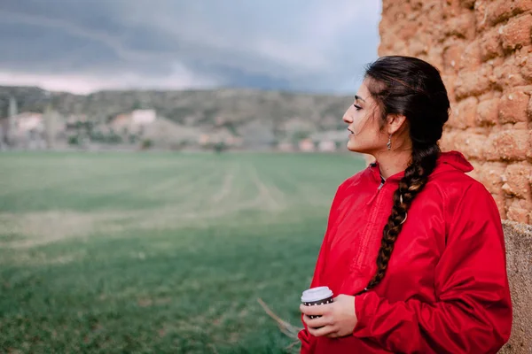 Girl wearing red raincoat observes the rain on the field — Stock Photo, Image