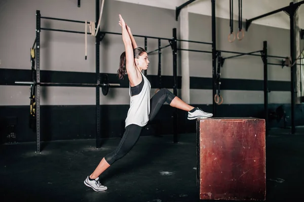 Joven mujer deportiva estirándose en el interior antes del ejercicio — Foto de Stock