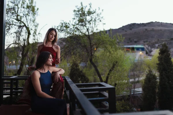 Две молодые женщины смотрят на закат с балкона . — стоковое фото