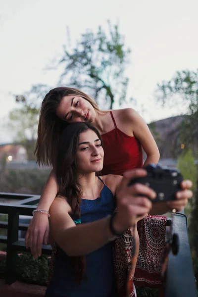Dwie młode kobiety robią selfie na balkonie. — Zdjęcie stockowe