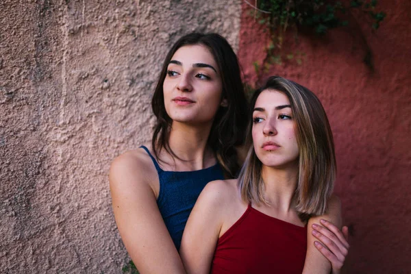 Две девушки смотрят на закат с двух цветных стен — стоковое фото
