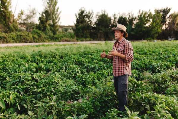 Joven granjero con sombrero trabajando en su campo — Foto de Stock