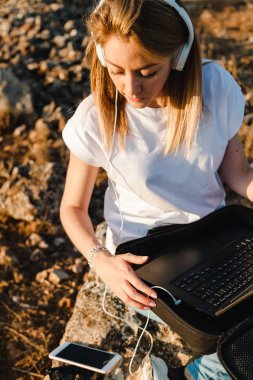 Dizüstü bilgisayarı olan genç bir kadın dış iletişimi dinledi.