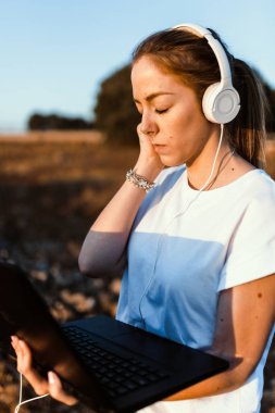 Dizüstü bilgisayarı olan genç bir kadın dış iletişimi dinledi.