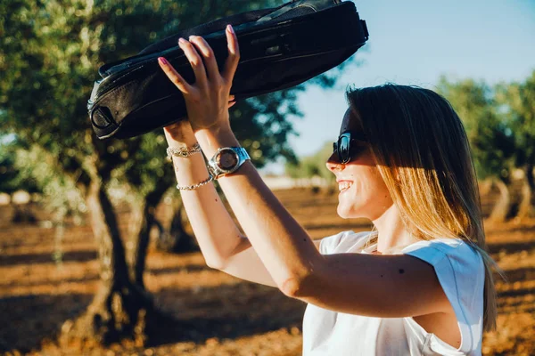 Jonge vrouw met een laptoptas door het veld van de olijfboom — Stockfoto