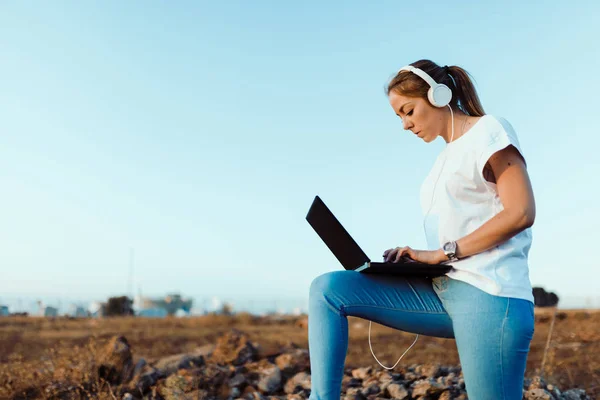 Jovem com seu laptop escutou comunicações externas — Fotografia de Stock