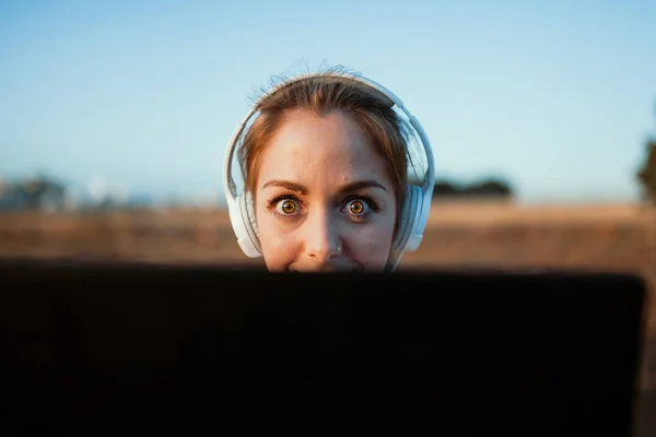 Giovane donna con il suo computer portatile ascoltato comunicazioni esterne — Foto Stock