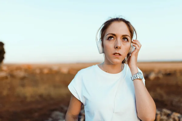 Young woman with her headphones listened external communications — Stock Photo, Image