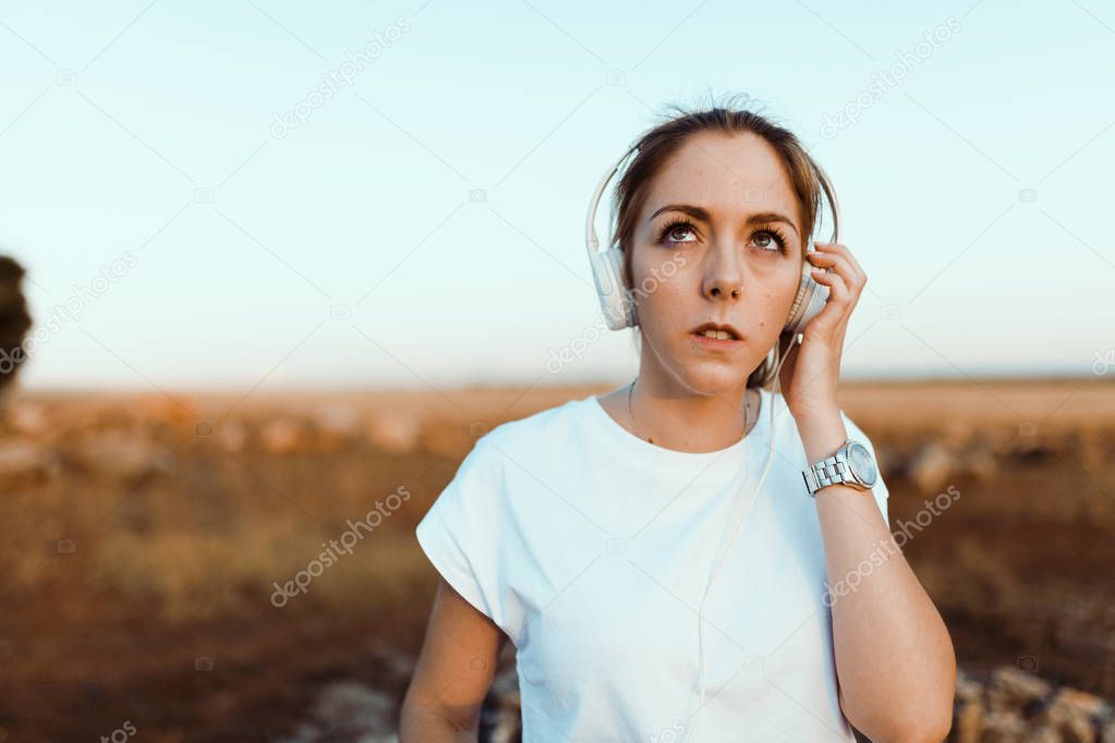 Young woman with her headphones listened external communications