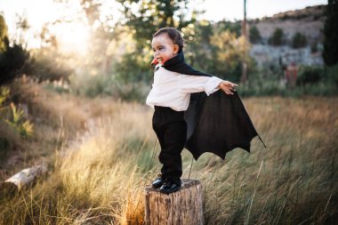 Çocuk ormanda cadılar bayramı için dracula kostümlü gülümseyen