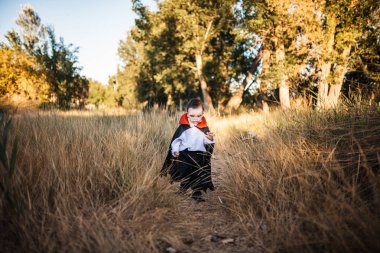 Çocuk ormanda cadılar bayramı için dracula kostümlü gülümseyen