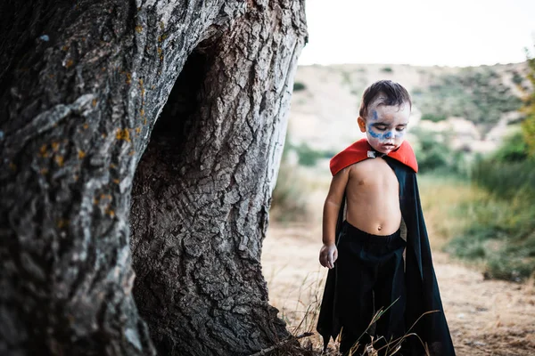 Miúdo sério fantasiado de dracula para halloween na floresta — Fotografia de Stock