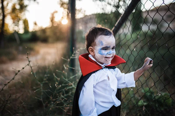 Criança sorrindo fantasiado de dracula para halloween na floresta — Fotografia de Stock