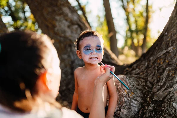 Kid pintando-se de dracula para halloween na floresta Imagens De Bancos De Imagens