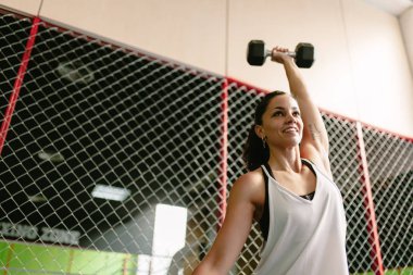 Fitness gülümseyen kadın spor salonunda bir dambıl kaldırma