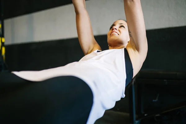 Bella donna muscolare che fa esercizio con sistema trx — Foto Stock