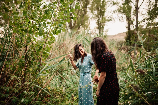 Zwei junge Frauen gehen durch das Feld — Stockfoto
