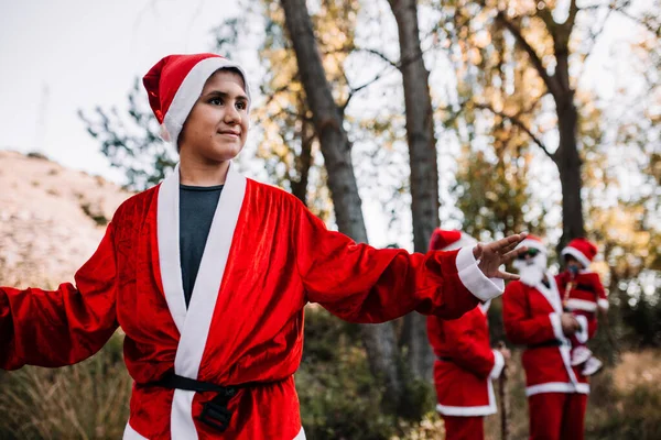 Gutt forkledd for julen på skogen med familien sin – stockfoto