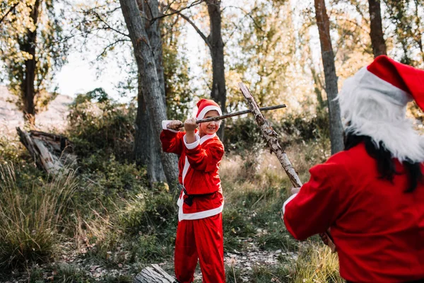 Mamma og sønn forkledd for julen leker de i skogen. – stockfoto