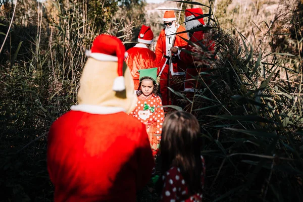 Gyerekek, akik az erdőben töltik a karácsonyt a családjukkal. — Stock Fotó
