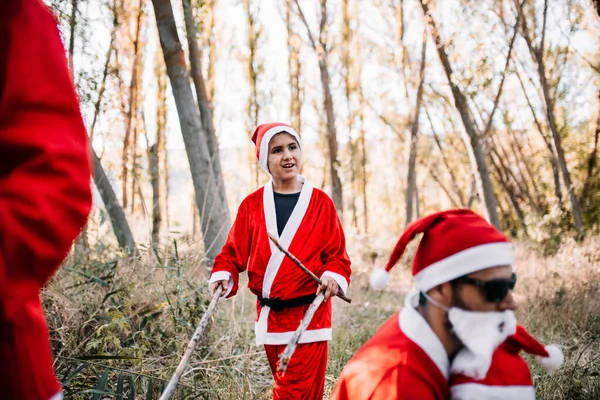 Emberek egy csoportja, akik karácsonynak álcázzák magukat az erdőben. — Stock Fotó