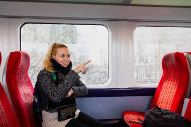 Hijyen maskeli bir kadın, koronavirüs yüzünden trenin koltuklarında güvenlik mesafesini koruyor.